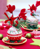 Cyclamen in Christmas tree balls with Nordic motifs as a vase