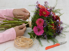 Tying a zinnias bouquet