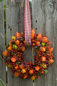 Wreath stuck with lanterns and rosehips