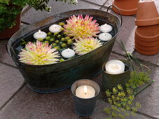 Tin tray with floating dahlia flowers and floating candles