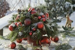 Gefrorener Weihnachtsstrauß aus Pinus (Kiefer) Zweige und Zapfen , Ilex