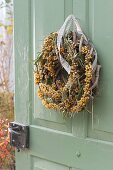 Door wreath of sea buckthorn on blank of dry tendrils