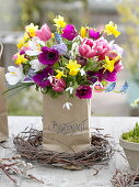Colorful spring bouquet in paper bag with inscription