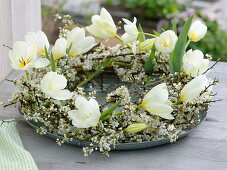 Wreath of white flowers, tulipa and Prunus spinosa branches
