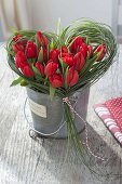 Valentinstrauss aus roten Tulpen im Gras-Herz