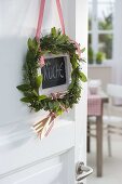 Wreath made of mediterranean herbs on the kitchen door