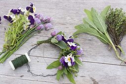 Tying a small wreath of herbs and edible flowers