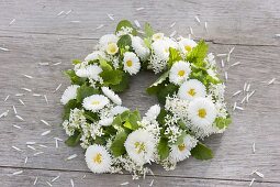 Tying a wreath of daisies and herbs