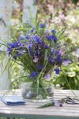 Blue bouquet of Aquilegia and grasses in glass bowl