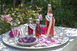 Bottles of rose liqueur and rose syrup, rose flowers