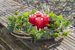 Adventskranz aus Hedera (Efeu) und Clematisranken mit roten Kerzen