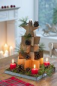 Stacked wooden stars as a fir tree, cones and branches