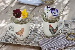 Oesterliche-Tischdeko in Tassen mit Hühner-Dekor