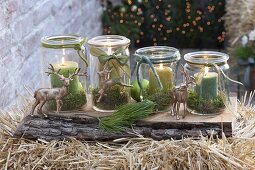 Advent wreath made of preserving jars with moss and green candles