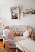 Cushions and fabric pig on sofa below shabby-chic mirror on wall