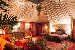 Zelt-Stil Boudoir Schlafzimmer mit marokkanischen Teppichen, orientalischen Stoffen und Beistelltisch