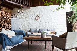 Lounge area on terrace with firewood stacked against wall