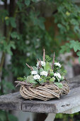 Wreath decorated with white asters and poppy seedheads on garden bench