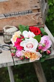 Bouquet of roses in various colours on weathered wooden table