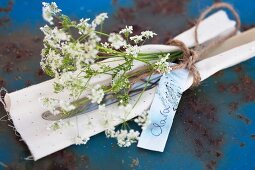 Cutlery, napkin and chervil tied with string and labelled with name tag