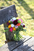 Bouquet of colourful ranunculus on weathered garden bench