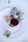 Posy with red ranunculus tied to vintage cutlery