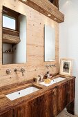Rustic washstand and wood-panelled wall in ensuite bathroom