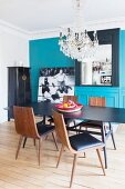 Turquoise wall and crystal chandelier in dining room