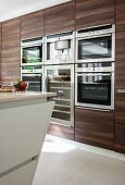 Dark wooden cupboards with integrated appliances in modern kitchen