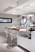 White island counter with solid wooden countertop and designer bar stools