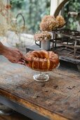 Hands of man cutting pound cake on cake stand