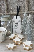 Arrangement of cinnamon stars and silver Christmas-tree ornaments