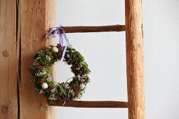 Easter wreath hung on rustic wooden ladder