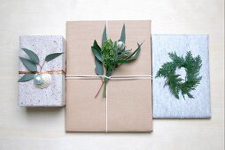 Wrapped gifts decorated with twigs, leaves and Christmas baubles