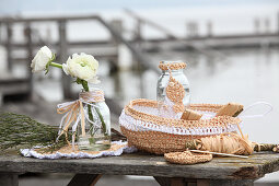 Crocheted raffia bread basket and doily and glass bottle decorated with raffia