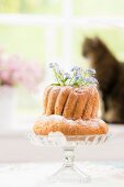 Forget-me-nots in bundt cake on glass cake stand