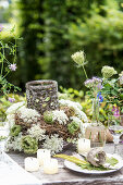 Gedeckter Tisch im Garten mit Wiesenblumen als Deko