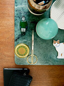 Figurines, scissors, stone sphere and metal vase on place mat