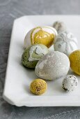 Various eggs decorated with hundreds and thousands on white porcelain plate
