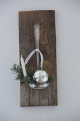 Christmas decorations in bowl of old ladle on wooden board