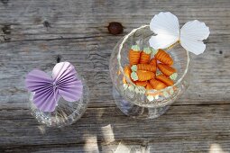 Folded paper butterflies on glasses and sugar carrots