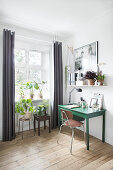Arbeitsecke mit grünem Schreibtisch, Retrostuhl und Zimmerpflanzen