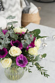 Bouquet of white roses, purple anemones and eucalyptus