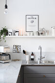 White modern kitchen with open shelves above marble counter