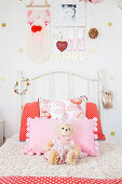 Weißes Bett mit Kissen und Kuscheltier im Mädchenzimmer