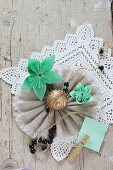 Folded paper flowers on lace and fabric rosette