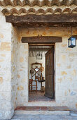 Open wooden front door of rustic stone house