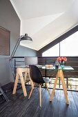 Glass desk on wooden trestles, classic chair and standard lamp on gallery