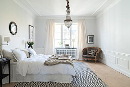 Elegantes Schlafzimmer mit Wandverkleidung und Stuckdecke