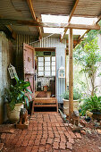 Löwenskulpturen und bepflanzte Tröge auf Vintage Veranda mit Ziegelplatten